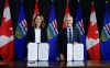 Prime Minister Mark Carney, right, signs an MOU with Alberta Premier Danielle Smith in Calgary on Thursday, Nov. 27, 2025. THE CANADIAN PRESS/Jeff McIntosh