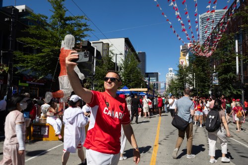 A man takes a selfie as soccer fans celebrate while Canada plays Qatar in FIFA World Cup group B soccer action, in Vancouver, on Thursday, June 18, 2026. THE CANADIAN PRESS/Chad Hipolito