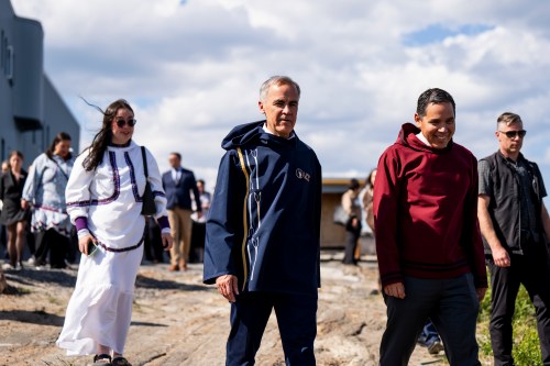 Prime Minister Mark Carney, centre, President of Inuit Tapiriit Kanatami, Natan Obed, right, and President of the National Inuit Youth Council Gwen Natsiq walk in Kuujjuaq, Nunavik, Que., on Tuesday, June 30, 2026. THE CANADIAN PRESS/Christopher Katsarov