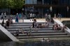 People sit on stairs on the Halifax Waterfront as some people swim to cool off in Halifax on Thursday, July 6, 2023. THE CANADIAN PRESS/Darren Calabrese