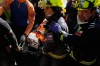 Chilean rescue workers carry Hernán Alberto Gil Flores after he was pulled from the rubble eight days after he was trapped by twin earthquakes that struck Catia La Mar, Venezuela, Thursday, July 2, 2026. (AP Photo/Fernando Vergara)