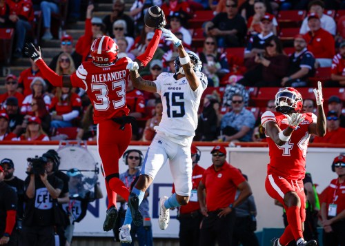 Toronto Argonauts' Makai Polk (15) reaches for a pass as Calgary Stampeders' Zy Alexander intercepts during first half CFL football action in Calgary, Thursday, July 2, 2026. THE CANADIAN PRESS/Jeff McIntosh