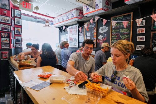 People wearing World Cup shirts taste sandwiches at Pauli's sandwich shop in the North End of Boston, Wednesday, June 24, 2026. (AP Photo/Martin Meissner)