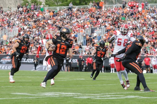 B.C. Lions quarterback Nathan Rourke (12) rushes for a first down against the Calgary Stampeders during first half CFL football action in Kelowna, B.C., on Saturday, June 27, 2026. THE CANADIAN PRESS/Steve Dunsmoor