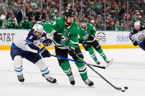 FILE - Dallas Stars left wing Jamie Benn (14) takes control of the puck in front of Winnipeg Jets' Alex Iafallo (9) in the first period of an NHL hockey game April 2, 2026, in Dallas. (AP Photo/Tony Gutierrez, File)