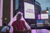 A Taylor Swift fan wearing a wedding veil sits at a restaurant next to Madison Square Garden where a 