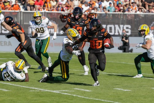 B.C. Lions' James Butler (20) runs past Edmonton Elks' Richard Jibunor (96) during first half CFL football action in Kelowna, B.C., on Saturday July 4, 2026. THE CANADIAN PRESS/Steve Dunsmoor