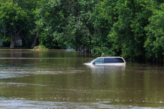A van sits in a flooded street in Swan River on Thursday. (Mike Deal / Pool / The Canadian Press files)
