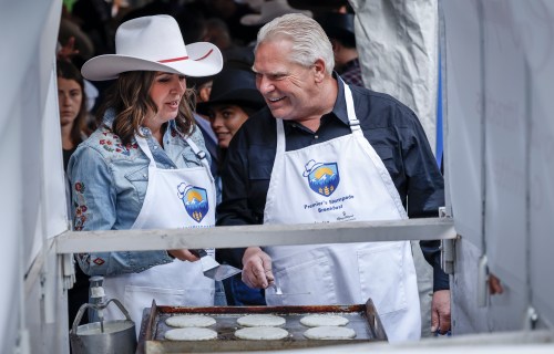 Alberta Premier Danielle Smith, and Ontario Premier Doug Ford cook pancakes at the annual Stampede breakfast in Calgary, Monday, July 7, 2025. THE CANADIAN PRESS/Jeff McIntosh