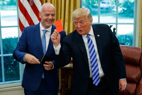 FILE - President Donald Trump holds up a red card during a meeting with FIFA president Gianni Infantino in the Oval Office of the White House, Tuesday, Aug. 28, 2018, in Washington. (AP Photo/Evan Vucci, File)