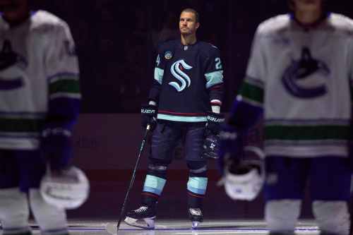 Seattle Kraken defenseman Jamie Oleksiak (24) listens to the National Anthem before a preseason NHL hockey game against the Vancouver Canucks Sunday, Sept. 21, 2025, in Seattle. (AP Photo/John Froschauer)