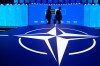 Two men walk past the NATO logo during the NATO Defense Industry Forum at the NATO summit in Ankara, Turkey, Tuesday, July 7, 2026. (AP Photo/Hussein Malla)