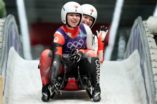 Canada's Beattie Podulsky, left, and Kailey Allan, right, arrive at the finish during a women's doubles luge run at the 2026 Winter Olympics, in Cortina d'Ampezzo, Italy, Wednesday, Feb. 11, 2026. (AP Photo/Aijaz Rahi)