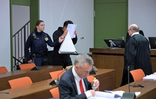 The defendant covers his face as he arrives for a trial against a network of mostly Chinese men, organized in chat groups to advise one another on how to drug and rape mostly Chinese women, in Munich, Germany, Feb. 2, 2026. (Malin Wunderlich/dpa via AP)