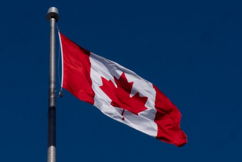 The Canadian flag is seen flying behind the national archives building in Ottawa Friday, Feb. 14, 2025, in Ottawa. THE CANADIAN PRESS/Adrian Wyld
