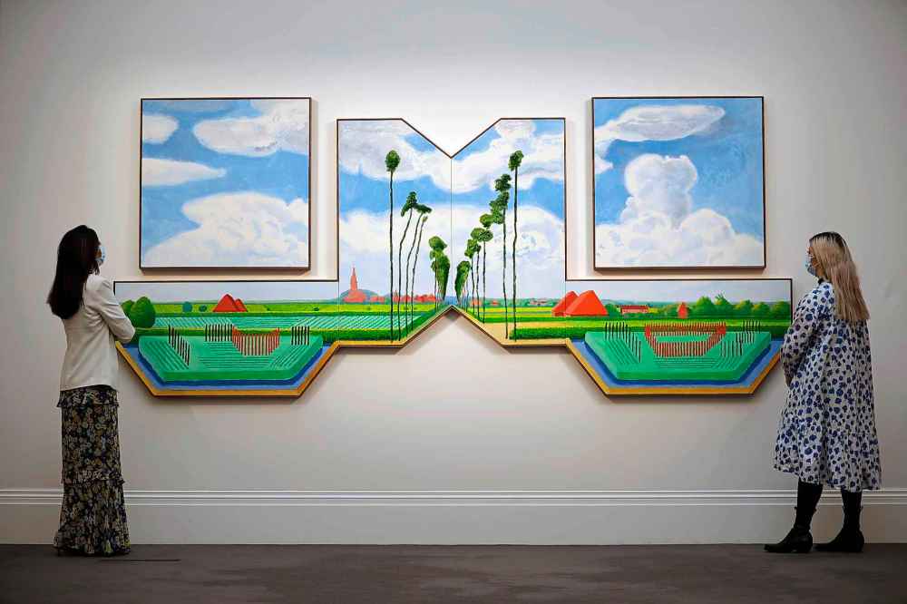 Staff members pose for photographs with British artist David Hockney's triptych