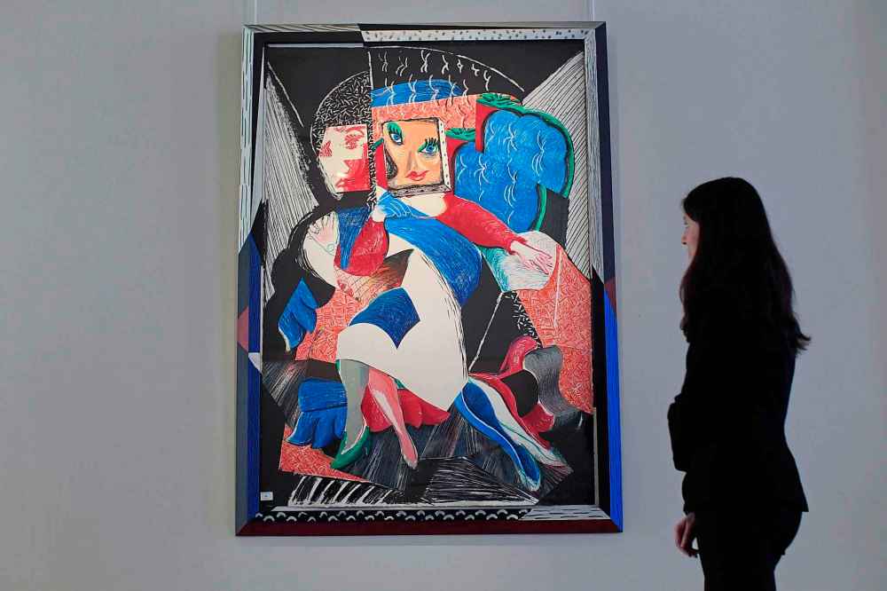 Bonhams' employee Ana Paiva from Portugal poses for photographs beside David Hockney's