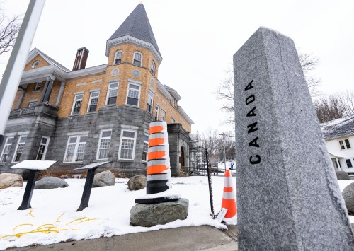 The border marker is seen beside the Haskell Free Library and Opera House in Stanstead, Que., on Friday, March 21, 2025. THE CANADIAN PRESS/Christinne Muschi