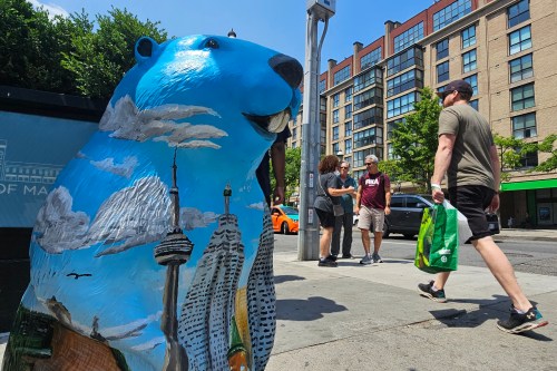 Pedestrians pass around the Old Toronto beaver sculpture, near the St. Lawrence Market, in Toronto, Friday, June 5, 2025. THE CANADIAN PRESS/Giordano Ciampini