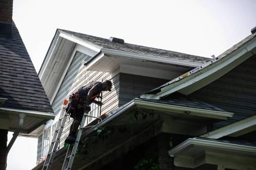 MIKAELA MACKENZIE / FREE PRESS 	 Anthony Antoine, with Pristine Siding and Roofing, works on installing eavestroughs on a house in Winnipeg on Friday, July 10, 2026. For Aaron story. Free Press 2026