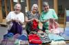RUTH BONNEVILLE / FREE PRESS Nancy Sperling (from left), Elaine Lochhead and Lynnette Stamler of the Hooks and Needles knitting group with some of the wares inside Epiphany Lutheran Church.
