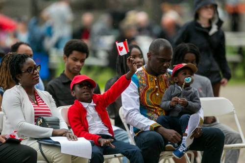 BROOK JONES / FREE PRESS
                                Paun holds a Canadian flag during the citizenship ceremony at The Forks with his mother, Lynda, father, Patrick and brother, Mathis.