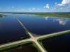 25062026 Flood waters from the swollen Assiniboine River cover farmland and submerge portions of a grid road bisecting Highway 250 north of Alexander on Thursday. (Tim Smith/The Brandon Sun)default