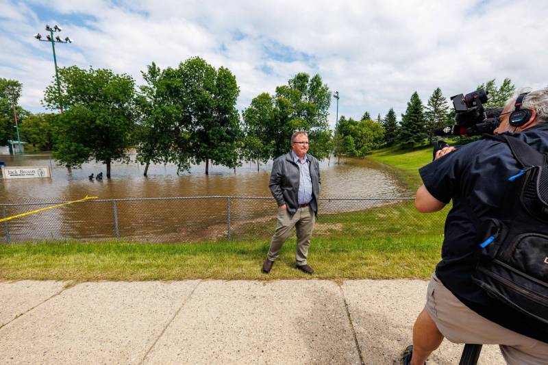MIKE DEAL / FREE PRESS
                                Swan River Mayor Lance Jacobson in front of the town&rsquo;s flooded Jack Brown Memorial Field Thursday.