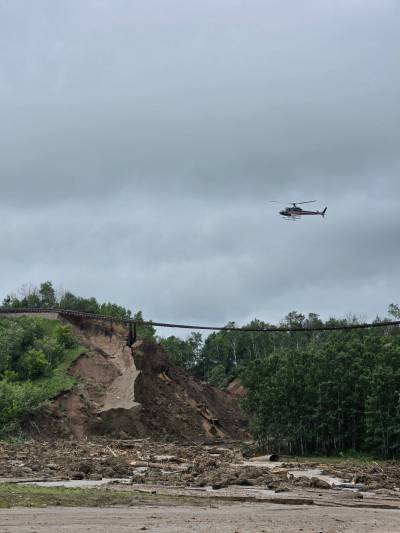 RICHARD SUIDAK PHOTO
                                A helicopter can be seen looking over a section of CN Rail line that was damaged by flooding in the Parkland region on Tuesday.