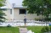 MIKE DEAL / FREE PRESS
                                A person watches the water flow along 3rd Street North in Swan River Thursday. Some properties still had standing and moving floodwater as of Saturday.