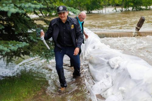 MIKE DEAL / FREE PRESS FILES
                                Manitoba Premier Wab Kinew crosses a flooded street after helping move a generator during a visit to Dauphin and Swan River last week.