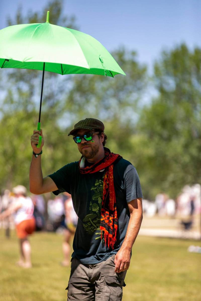 BROOK JONES/FREE PRESS 
                                Winnipeg&rsquo;s Ian Zienkicz, who is attending his 18th Winnipeg Folk Festival, uses an umbrella to keep cool on Sunday.