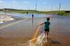 Tim Smith/The Brandon Sun
                                Brooks and Emily Zamrykut wade in the flood waters of the Assiniboine River pouring over Grand Valley Road near the Trans Canada Highway in Brandon on a scorching hot Monday afternoon.