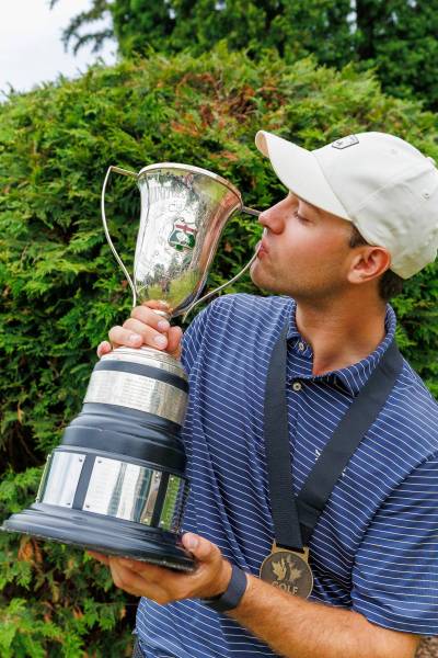 MIKE DEAL / FREE PRESS
                                Glendale Golf and Country Club&rsquo;s Rory Neill kisses the trophy Wednesday after winning his first men&rsquo;s amateur championship.