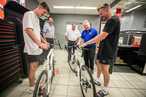Thomas Clark (left) and Val Duquenne greet Canadian Tire folks Brad Elliott (left), Marc Gaudreau, and Chris Coenen with their new bikes on Monday. (Mikaela MacKenzie / Free press)