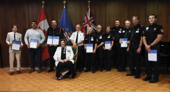 From left: Knox Nickel, Preston Waide Houle, and members of Pinawa Fire and Rescue Service pose for a photo with Lt.-Gov. Anita Neville. (John Woods / Free Press)