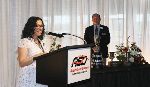 GEORGE WILLIAMS PHOTO
                                Nellie Kennedy, Manitoba Minister of Sport, Culture, Heritage and Tourism, speaks to a packed crowd at Assiniboia Downs during the Press Conference for the 78th running of the $125,000 Manitoba Derby on Friday, as Downs CEO Darren Dunn watches from the background with the trophies. Manitoba&rsquo;s signature race goes Monday evening.