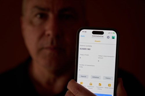 Chris Colocousis holds up a screenshot of the fake app where he invested his savings showing his account had more than doubled to nearly $826,000 as part of a scam in which he says he lost $400,000 at his home in Raynham, Mass., Tuesday, March 10, 2026. (AP Photo/David Goldman)