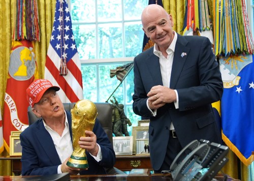FILE - President Donald Trump holds the FIFA World Cup Winners Trophy as FIFA President Gianni Infantino looks on during an announcement in the Oval Office of the White House, Aug. 22, 2025, in Washington. (AP Photo/Jacquelyn Martin, File)