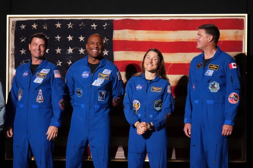 Artemis II crew members Reid Wiseman, from left, Victor Glover, Christina Koch and Jeremy Hansen stand as President Donald Trump speaks during Salute to America, an Independence Day event honoring the nation's 250th anniversary, Saturday, July 4, 2026, on the National Mall in Washington. (AP Photo/Mark Schiefelbein)