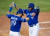 Blue Jays sluggers Jose Bautista, left, and Edwin Encarnacion celebrate scoring on a three-RBI double by Troy Tulowitzki during Game 5 of the American League Championship Series against the Kansas City Royals in Toronto on Oct. 21, 2015. THE CANADIAN PRESS/Darren Calabrese