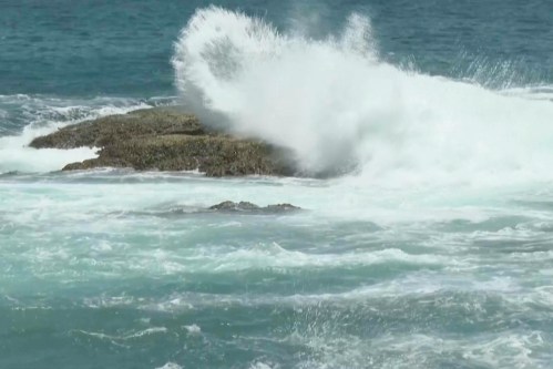 In this image made from video, waves crash on rocks ahead of Typhoon Bavi along the coast of Keelung in northern Taiwan on Thursday, July 9, 2026. (AP Photo/Taijing Wu)