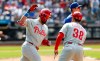Philadelphia Phillies' Kyle Schwarber, left, celebrates with first base coach Paco Figueroa (38) after hitting a two-run home run against the New York Mets during the seventh inning of a baseball game, Sunday, June 28, 2026, in New York. (AP Photo/Noah K. Murray)