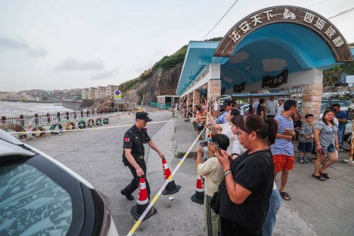 In this photo released by Xinhua News Agency, a security person cordons off the coastal area ahead of Typhoon Bavi's expected arrival in Shitang Town of Wenling City, eastern China's Zhejiang Province, Friday, July 10, 2026. (Xu Yu/Xinhua News Agency via AP)