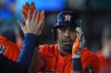 Houston Astros' LaMonte Wade Jr. is congratulated in the dugout after hitting a grand slam during the third inning of a baseball game against the Texas Rangers, Saturday, July 11, 2026, in Arlington, Texas. (AP Photo/LM Otero)