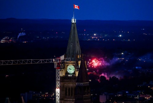 A small fireworks display is seen past the Peace Tower on Parliament Hill on Canada Day in Ottawa on Monday, July 1, 2024. THE CANADIAN PRESS/Justin Tang