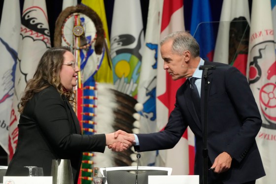 Prime Minister Mark Carney (right) shakes hands with AFN National Chief Cindy Woodhouse Nepinak in 2025. (Adrian Wyld / The Canadian Press files)