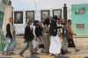 Houthi supporters walk in front of posters of some top Iranian scientists who have been killed in Israeli strikes, in Sanaa, Yemen, Monday, July 13, 2026. (AP Photo/Osamah Abdulrahman)