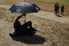A spectator shelters from the sun as they watch a practice round for the British Open Golf championships at Royal Birkdale golf club, in Southport, England, Tuesday, July 14, 2026. (AP Photo/Jon Super)