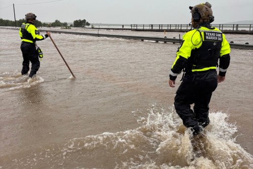 In this handout photo provided by the Texas Parks and Wildlife Department, game wardens walk through high waters from heavy rains in Uvalde County, Texas, on Tuesday, July 14, 2026. (Texas Parks and Wildlife Department via AP)